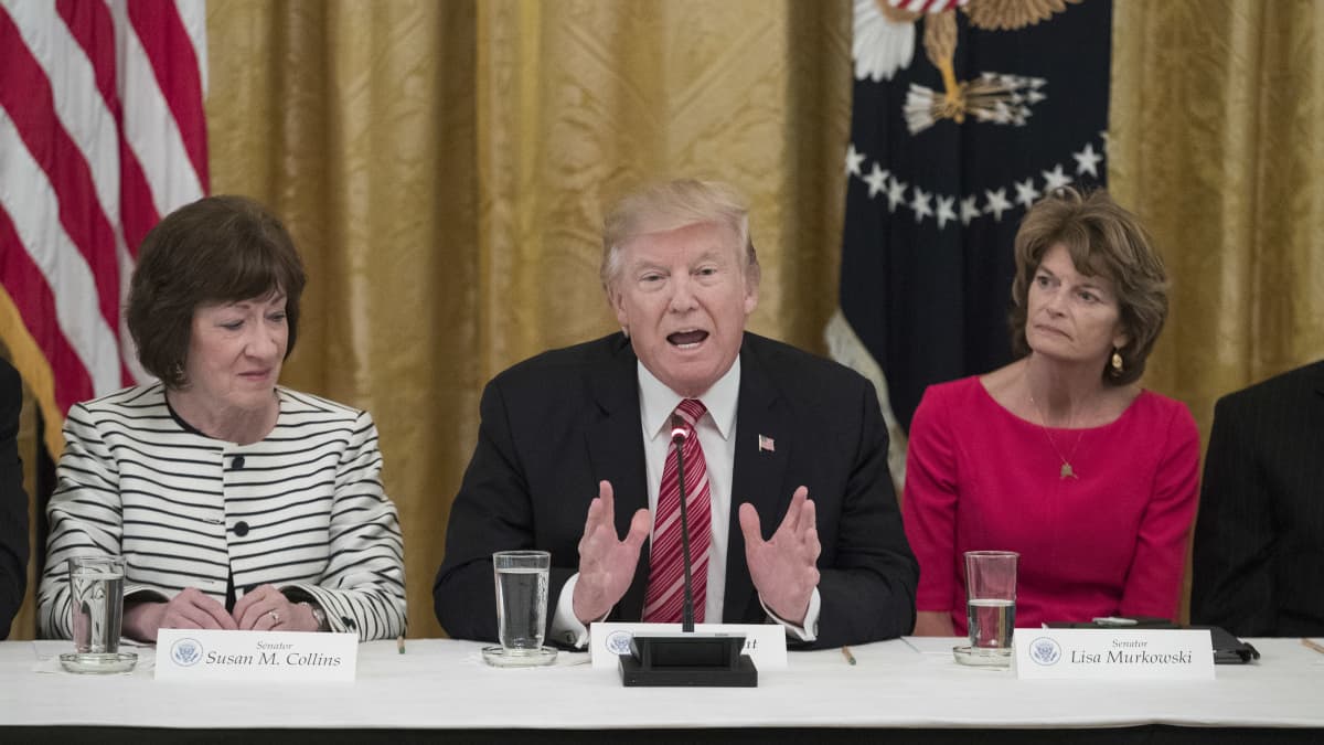 Susan Collins, Donald Trump ja Lisa Murkowski istuvat saman pöydän takana.