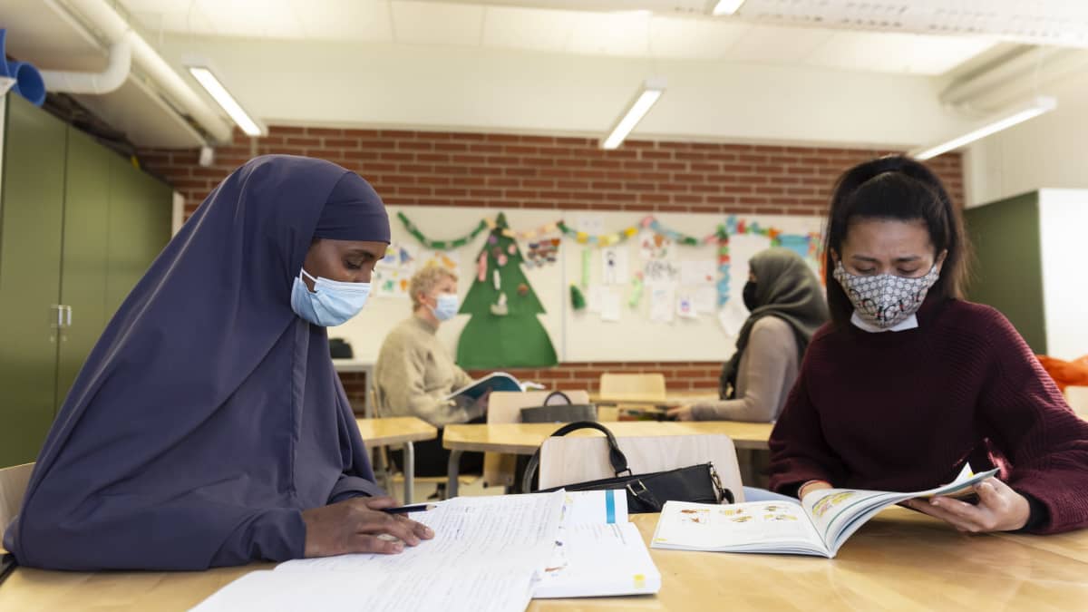 Maahanmuuttajataustaisia äitejä suomenkielen opetuksessa oppilaidensa koulussa.