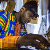 Dennis Owusu ompelemassa ompelukoneella