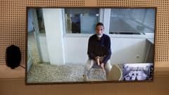 John Mcafee istuu tuolilla televisiokuvasas. Hänet kuvattiin videokuulemisessaan kesäkuun 15. päivä.