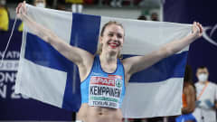 Lotta Kemppinen poseeraa Suomen lipun kanssa.
