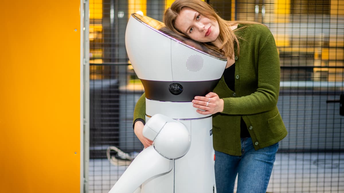 Sähkötekniikan opiskelija Raita Sandberg halaa robottia.