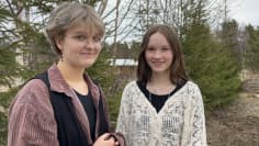 Emma Gahmberg ja Hilda Mustan potretti kaksi nuorta seisovat ja katsovat kameraan hymyillen.