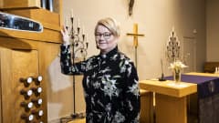 Haagan seurakunnan pappi Mari Mattsson nojaa urkuihin Huopalahden kirkossa. Kirkko tekee paljon mielenterveystyötä uskonnollisen työn ohella. 5.4.2023.