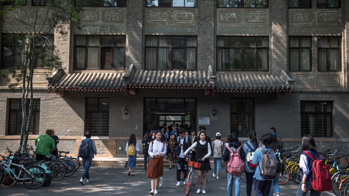opiskelijoita kävelee Pekingin yliopiston edustalla