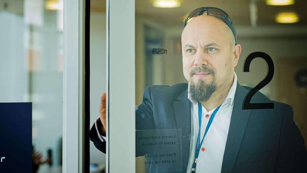 Jyväskylän yliopiston kauppakorkeakoulun yliopistonlehtori Tommi Auvinen avaa ovea.