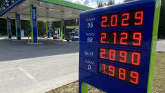 Sini-vihreä tankkausaseman kyltti, jossa punaisilla valokirjaimilla bensan ja dieselin hintoja. Pienin hinta dieselin 1 euroa ja 989 senttiä.