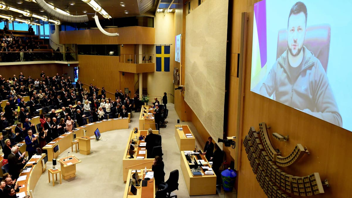 Volodymyr Zelenskyi näkyy videoscreenillä Ruotsin parlamentn seinällä.