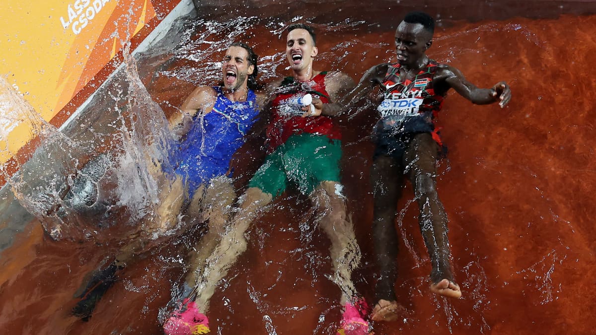 Korkeushypyn voittaja Gianmarco Tamberi hyppäsi vesiesteeseen juhlimaan 3000 metrin esteiden kultamitalistin Soufiane El Bakkalin ja pronssimitalistin Abraham Kibiwotin kanssa.
