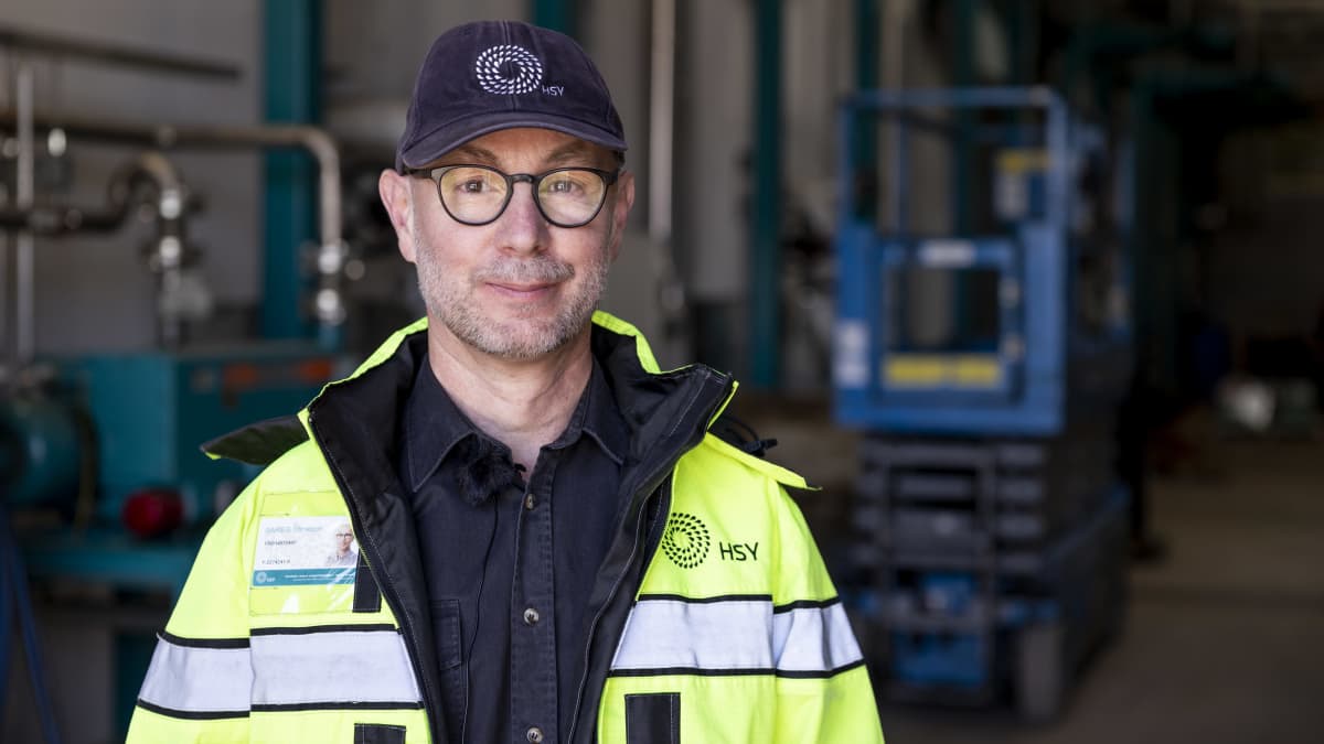 HSY:n biokierrätyksen toimintovastaava Christoph Gareis katsoo kameraan työmaatakki päällä ja HSY:n tummansininen lippalakki päässään.