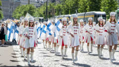 Nuoria naisia marssii valkoisissa uniformuissa Mannerheimintiellä.