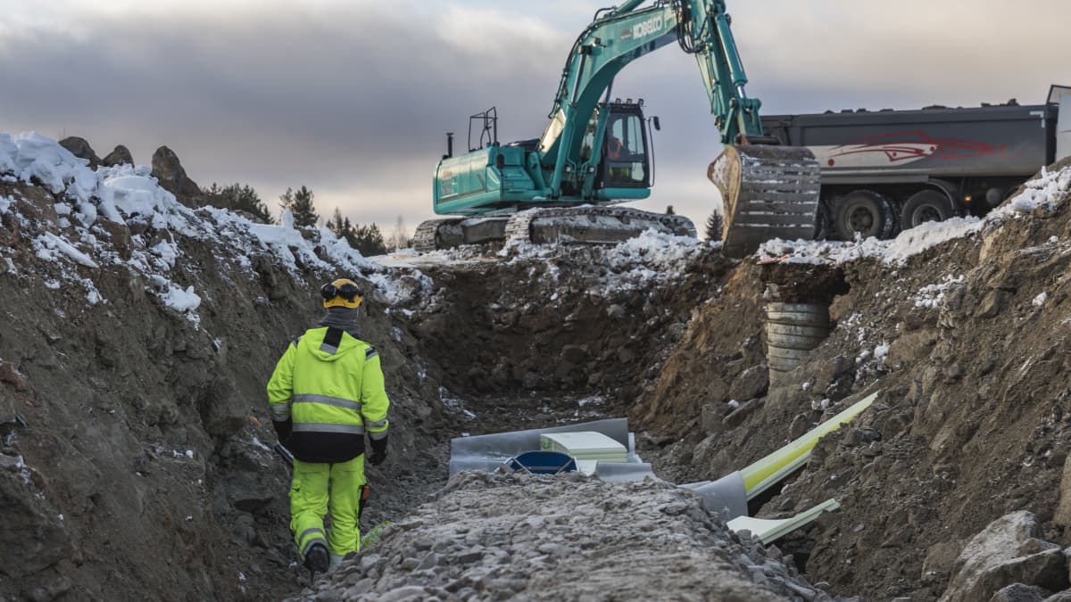 Kaivinkoneet kaivavat putkia maahan.