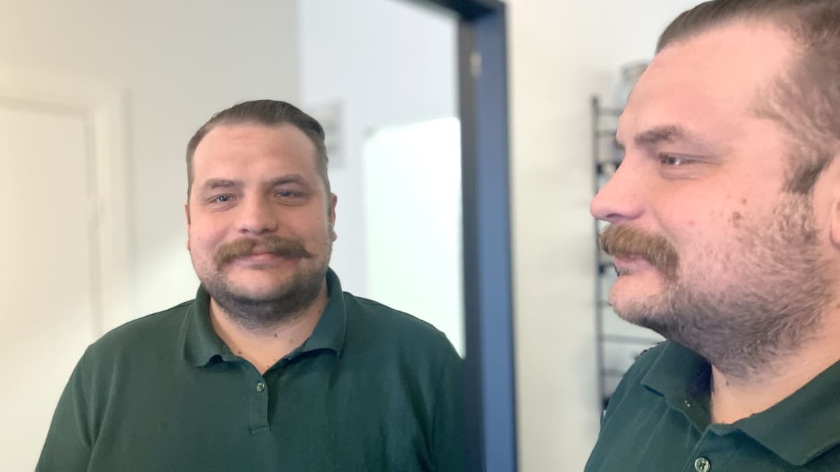 Veturinkuljettaj Rami Vilander seisoo ja katsoo peilin kautta kameraan.