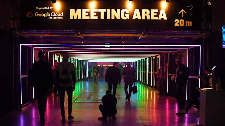 People walking in a lighted tunnel at the Slush start-up conference.