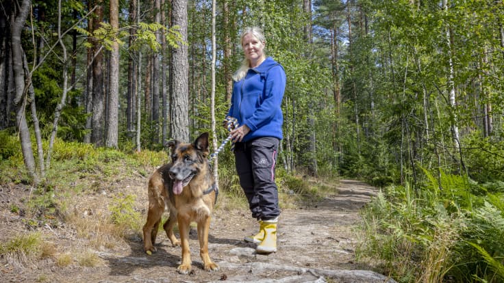 Nainen (Tanja Kammarback-Rossi Karjaalta) on koiransa kanssa metsäpolulla.