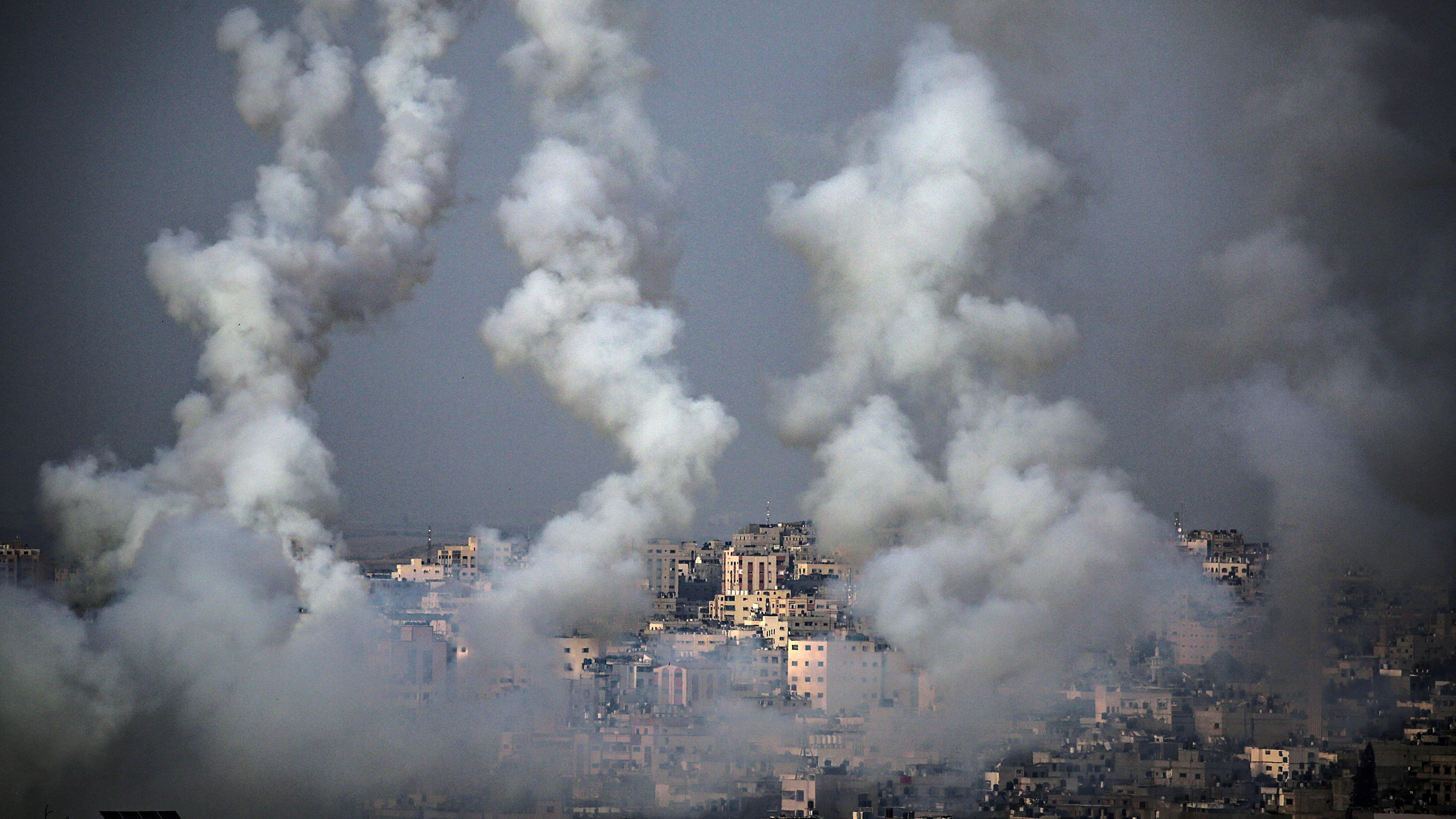Gazasta lähteneet rakettien savuvanat taivaalla kaupungin yläpuolella.