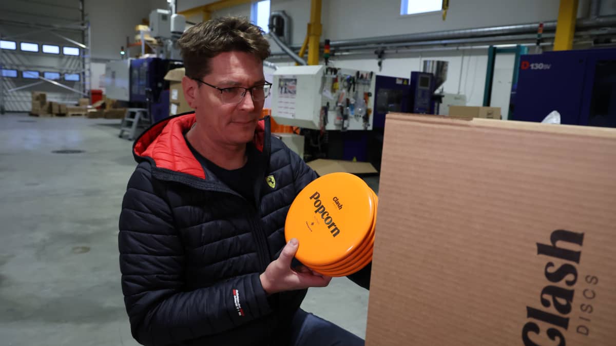 Frisbeegolfkiekkoyrittäjä Timo Nuutinen pakkaa vastavalmistuneita kiekkoja pahvilaatikkoon.