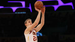 Valkoiseen Clevelandin pelipaitaan pukeutunut Lauri Markkanen heittää koripallon.