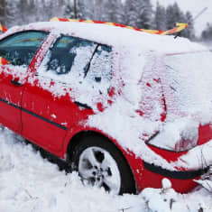 Auto ojassa Lehmon rampin lähellä Kuutostiellä. Ympärillä lunta.