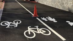 Pyörä- ja jalankulkutie, jossa valkoiset merkinnät maalattu asfalttiin.