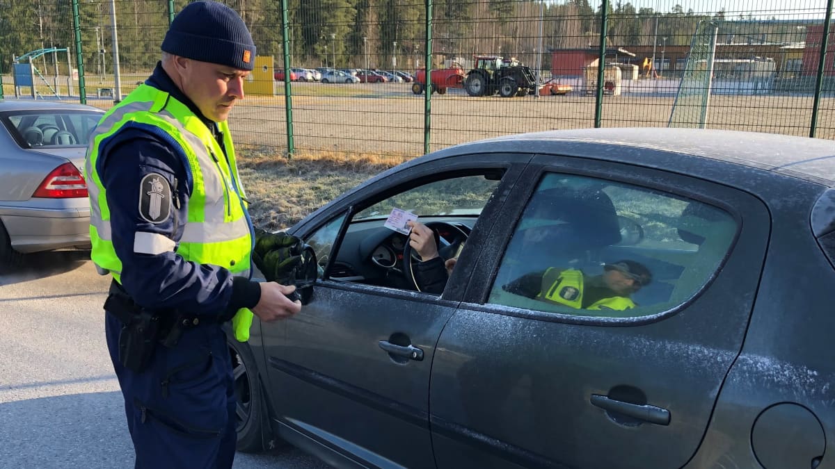 Ylikonstaapeli Juha Seppälä Lounais-Suomen poliisista katsoo autoilijan renkaita.