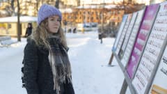 Jenni Kattelus katselee vaalijulisteita.