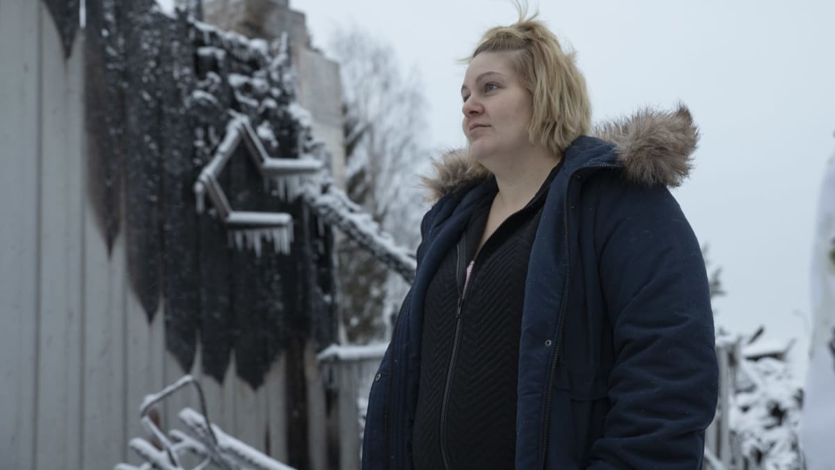 Kuopiolainen Nina Perämäki seisoo palaneen omakotitalon raunioiden edessä Kuopion Hiltulanlahdessa.