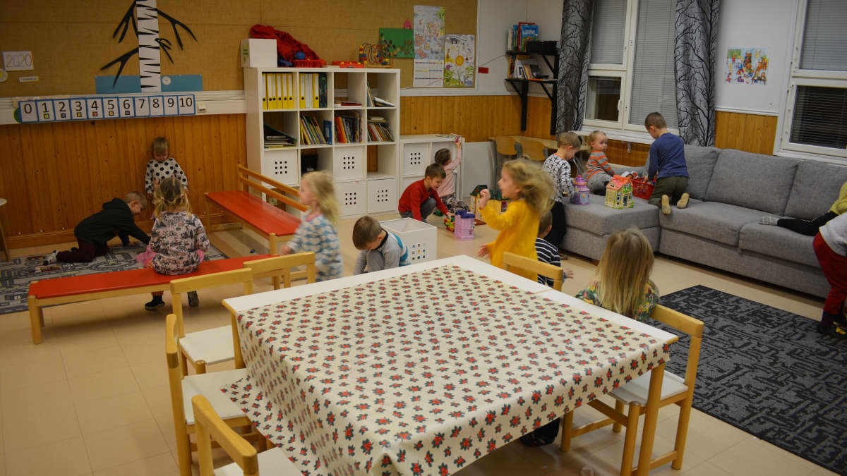 Päiväkotilapset leikkivät koululuokassa.