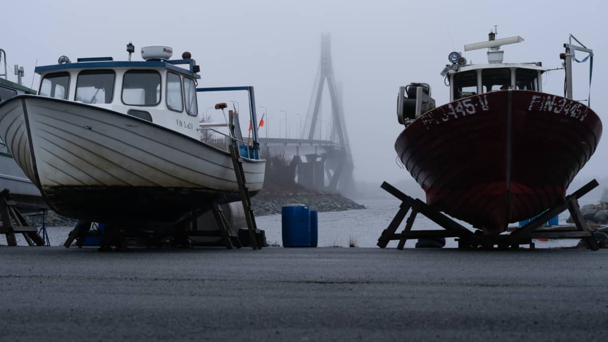 Raippaluodon silta talvisäilytykseen nostettujen kalastusveneiden takana.