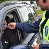 Poliisi tekee huumepikatestiä auton kuljettajalle.