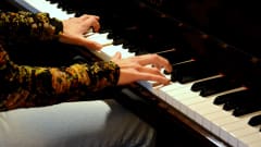 någon spelar på ett piano