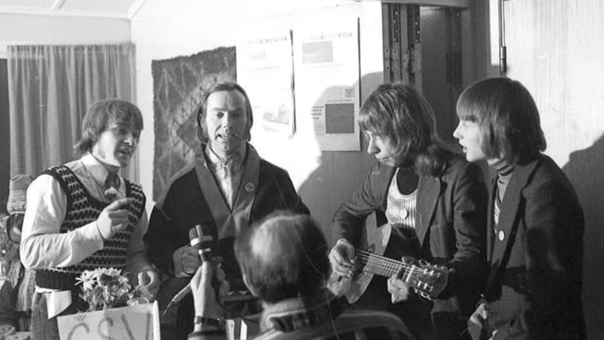 Mustavalkoinen kuva 1970-luvulta Tenon rannan nuorista laulamassa, joikaamassa ja soittamassa kitaraa. Hartvig Hansen, Ingvald Guttorm, Leif Wigelius, Jan Henriksen ja Paulus Utsi nauhoittamassa.