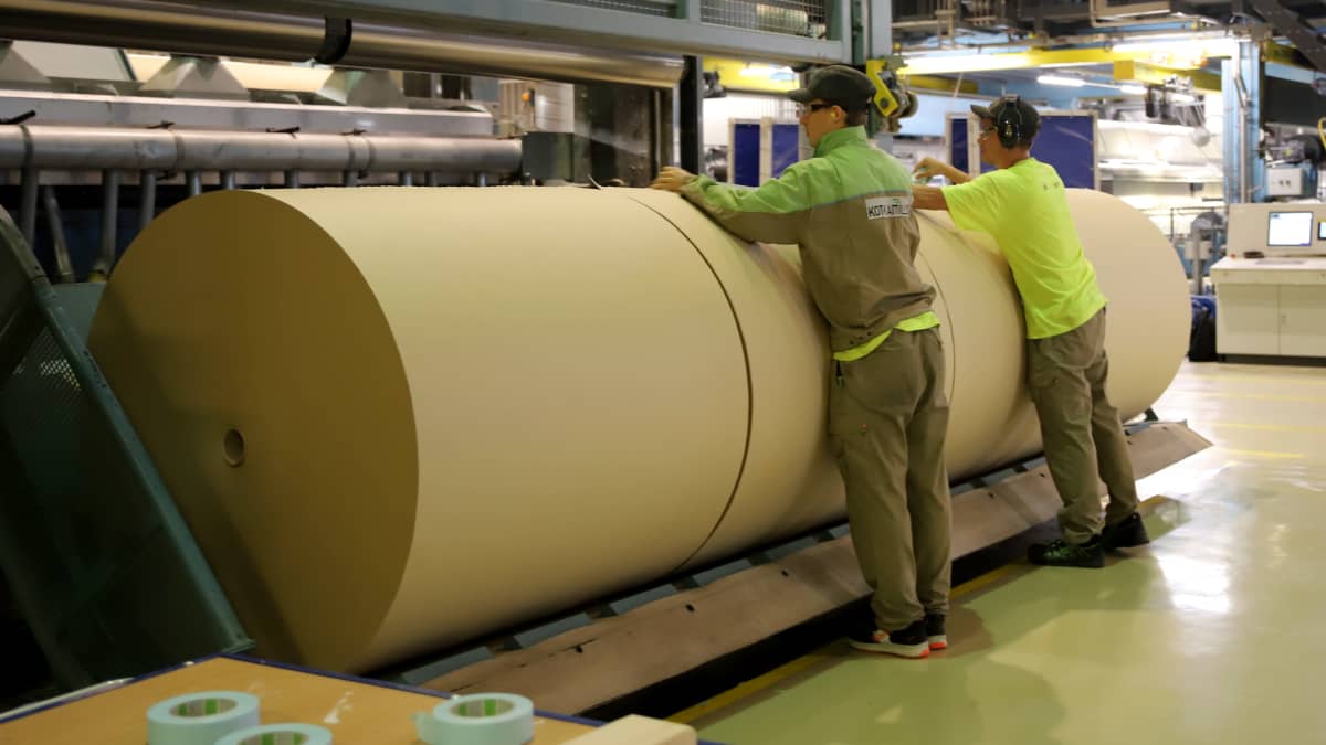 työntekijät teippaavat laminaattipaperirullia Kotkamillsin tehtaassa
