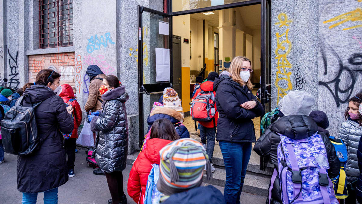Koululaisia koulun ovensuun edustalla Milanossa