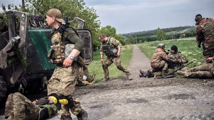 Ukrainalaiset sotilaat auttavat haavottuneita tovereitaan Donbassissa.