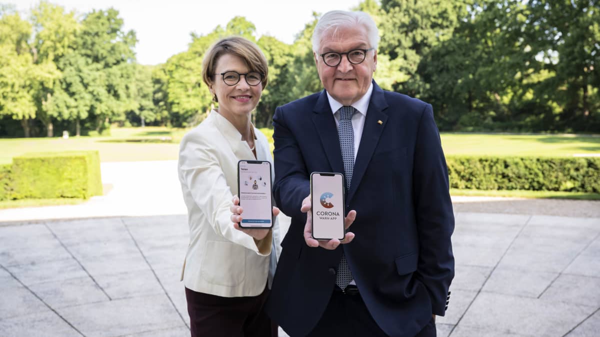Saksan presidentti Frank-Walter Steinmeier merkkinoi vaimonsa, Elke Elke Büdenbenderin kanssa tiistaina uutta koronavaroitussovellusta.