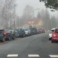 Bilar parkerade längs en väg. 