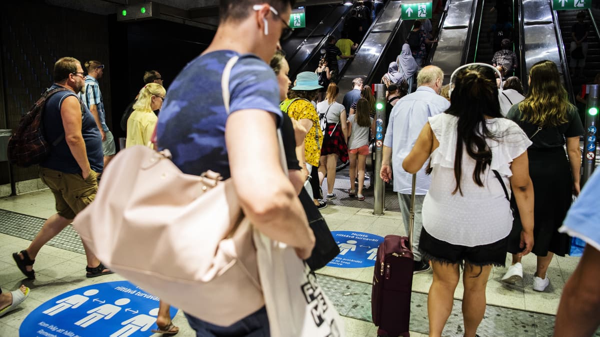Ihmiset poistuivat metroasemalta Helsingissä kesäkuun lopulla 2020.