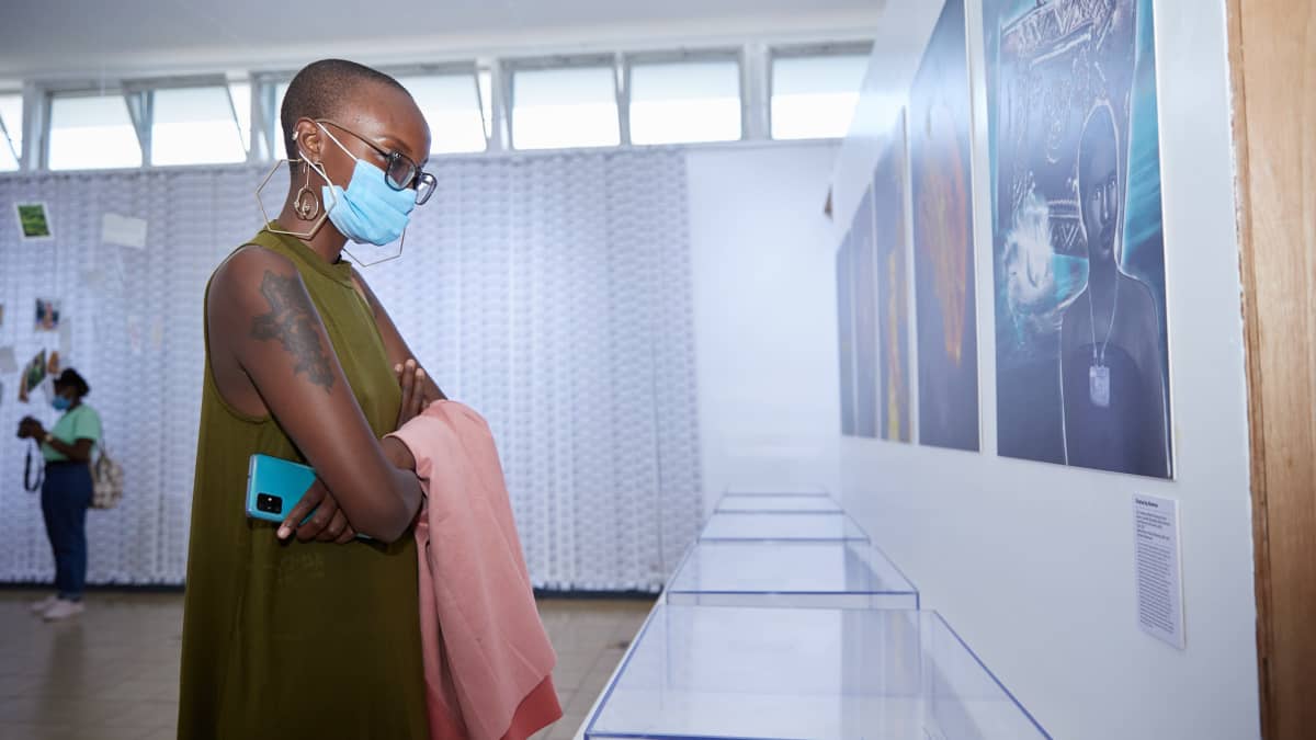 Nainen katselee tyhjiä näyttelyhyllyjä Invisible inventories -näyttelyssä Nairobissa Keniassa.