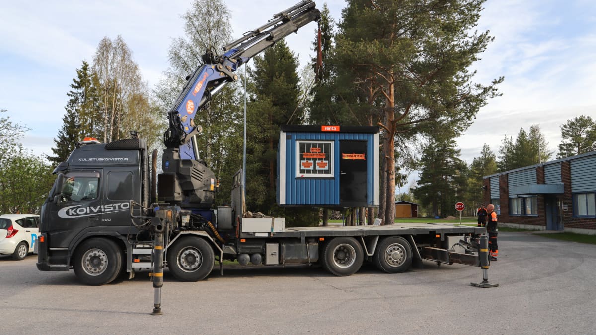 Koronatestikonttia siirretään kuorma-auton lavalle Pellossa. Testikontti siirtyy terveyskeskukselta Ruotsin rajalle.