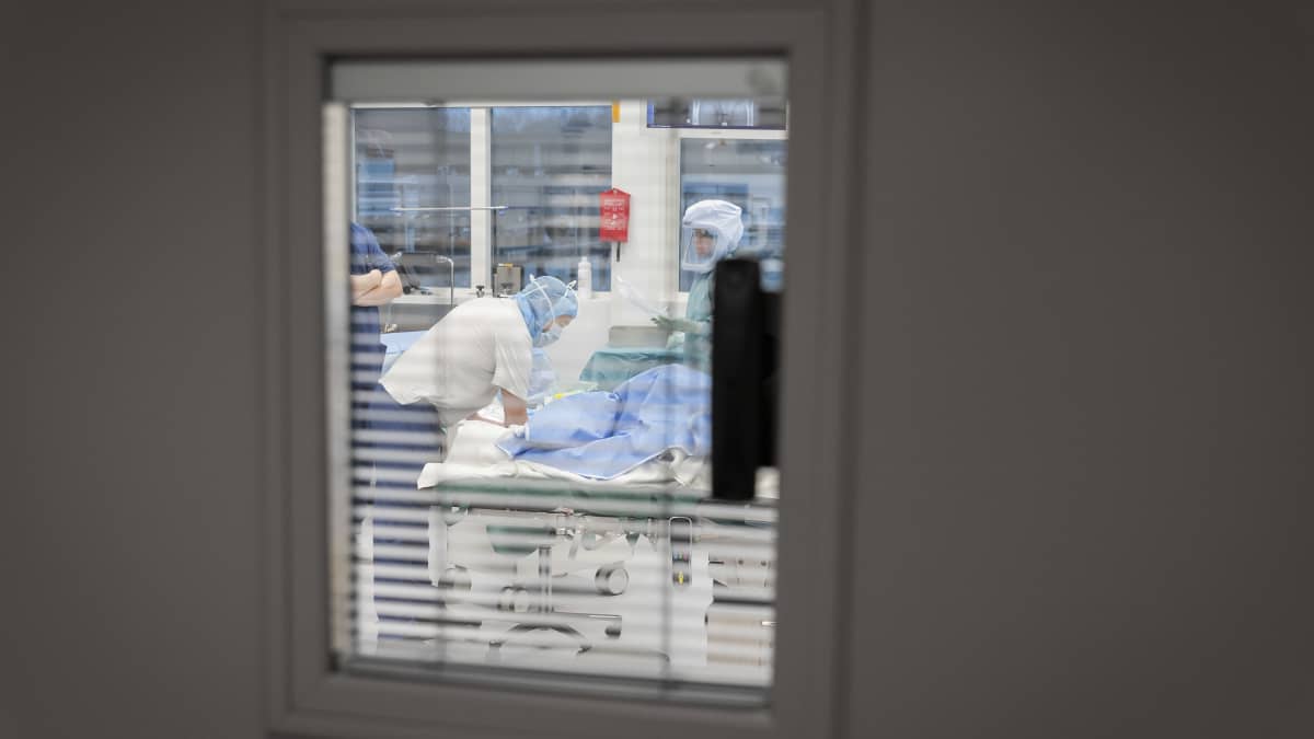 Ikkuna, josta näkyy leikkaussali ja hoitohenkilökuntaa. 