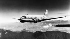 Toisen maailmansodan rahtilentokone Curtiss C-46 Commando lentää Himalajan vuoriston yläpuolella.