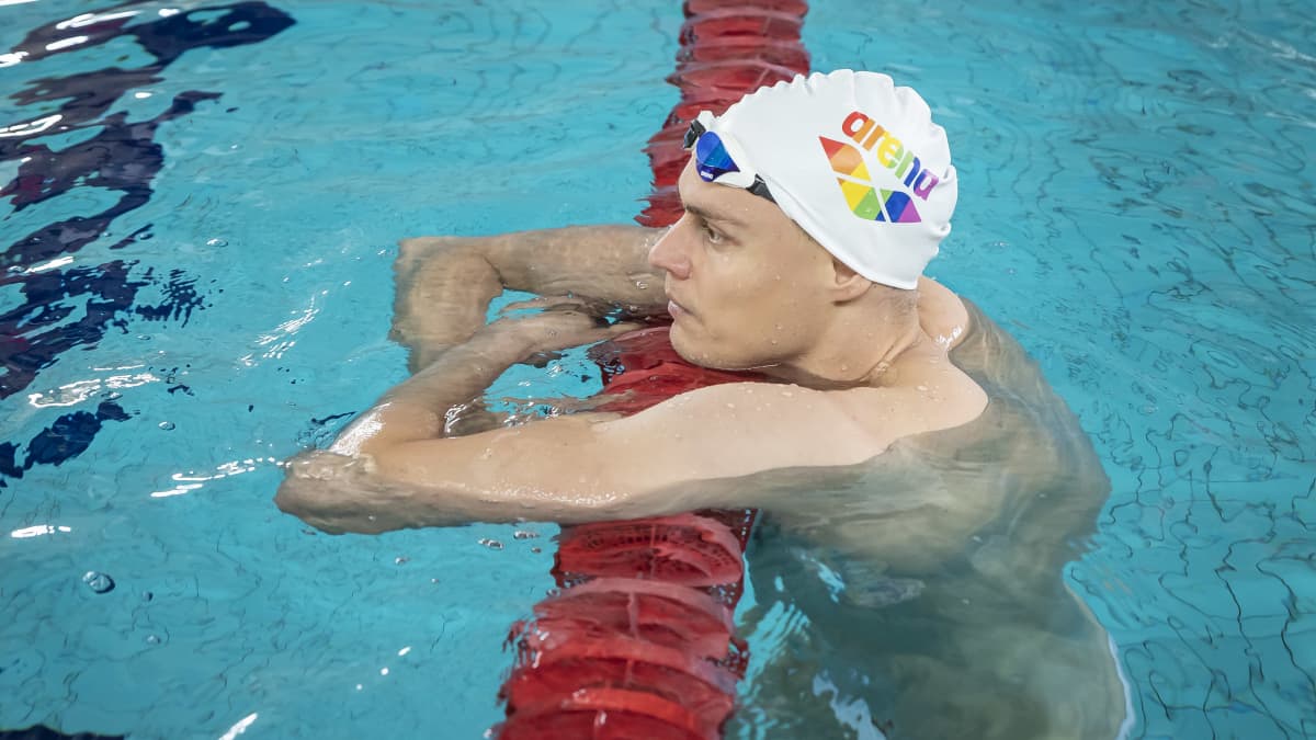 Uimari Ari-Pekka Liukkonen nojaa uima-altaan rataköyteen.