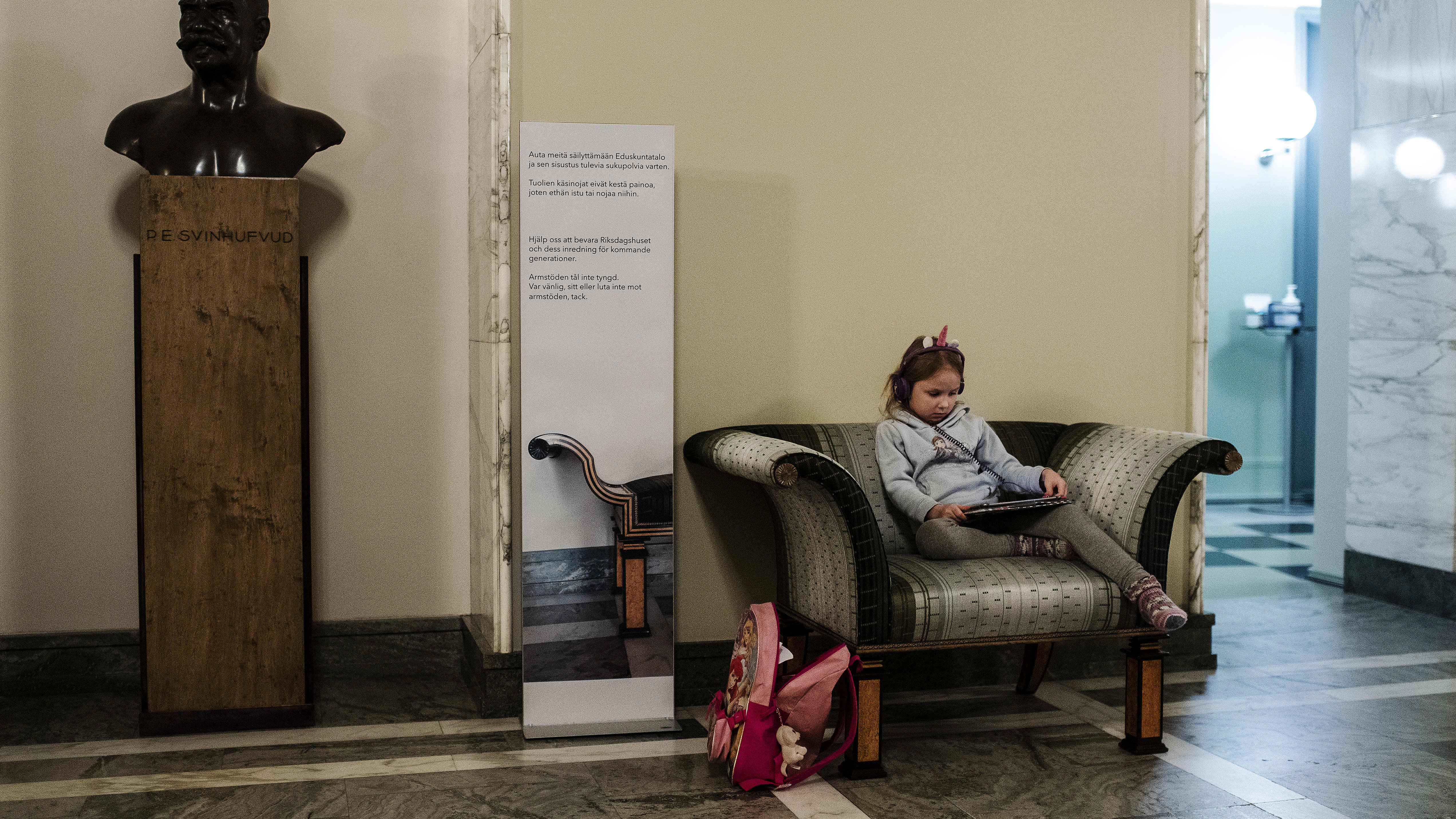 5-vuotias Minja Västinen katseli Netflixiä tabletilta eduskunnan valtiosalissa