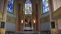 Kirkon alttarin yläpuolella on Jeesusta esittävä alttaritaulu ja lasimaalaukset.