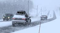 Two cars and a van on a road during a blizzard.