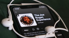 Puhelin jossa pyörii The Joe Rogan Experience Spotifyssa.
