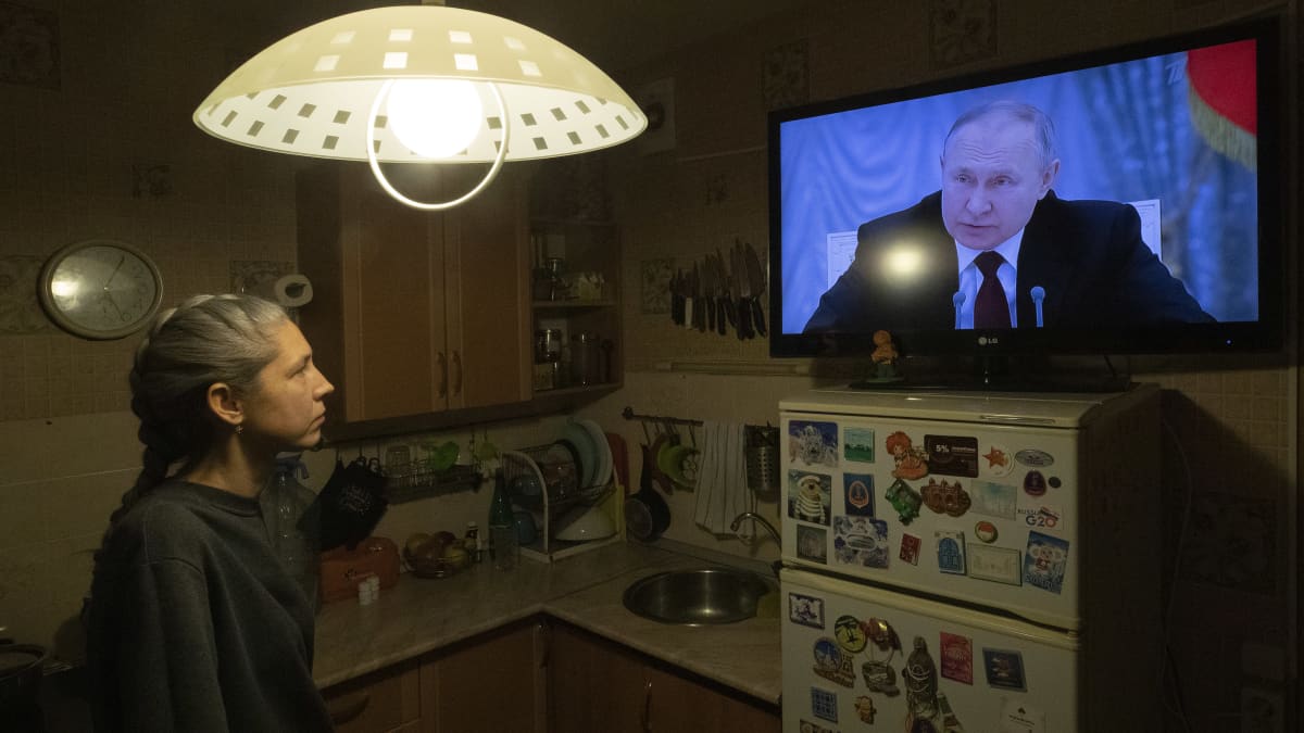Henkilö katsoo tv jossa lähetyksessä näkyy Vladimir Putin.