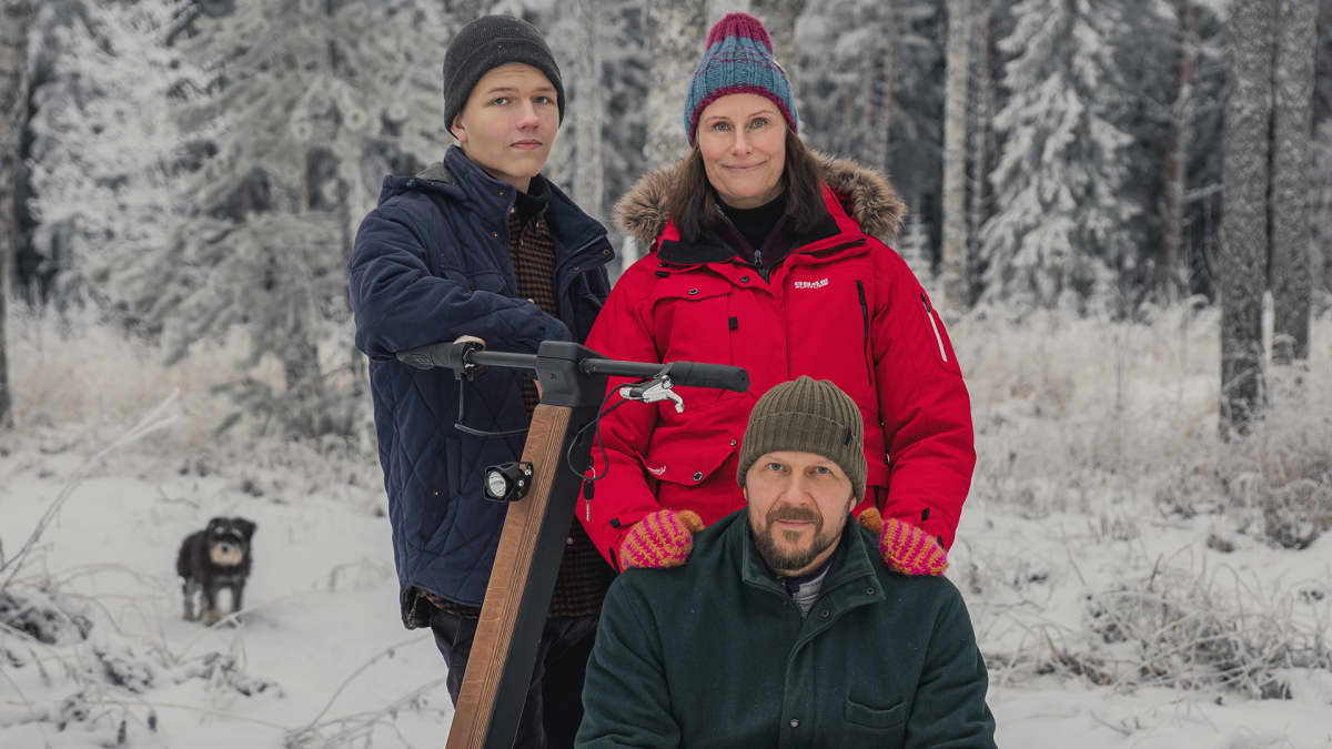 Kauppisen perhe poseeraa sähkölumiskootterin vierellä.