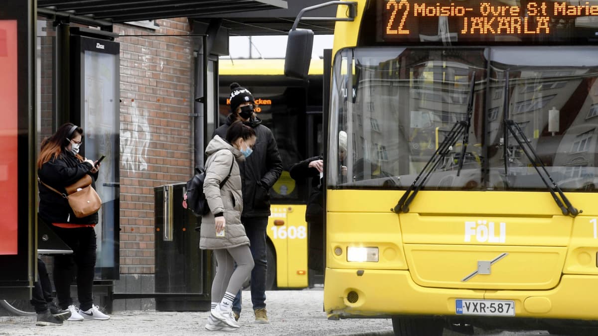 Ihmisiä ja linja-auto Turun keskustassa 22. maaliskuuta 2021.